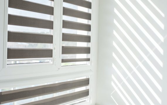 Roller blinds on balcony windows. Beautiful window blinds, sun protection